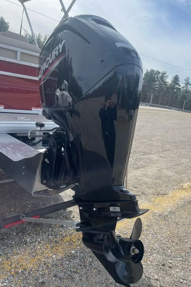 Slide: The Image of 2025 Sun Tracker Party Barge 20 DLX with Mercury outboard motor in a parking lot. - 7