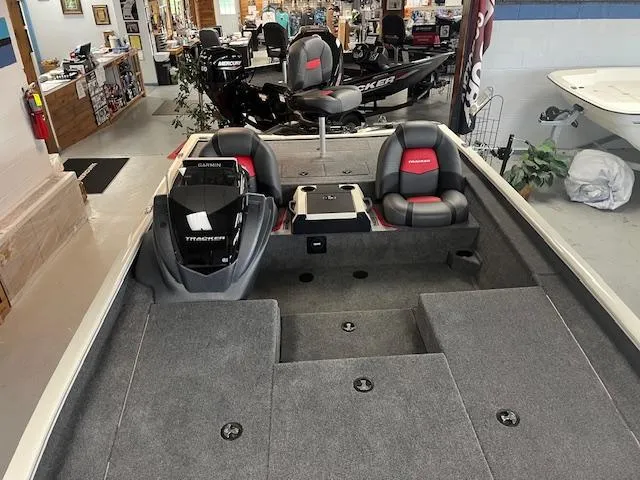 Slide: The Image of 2025 Tracker Savage 215 boat interior with seating and equipment in showroom. - 2