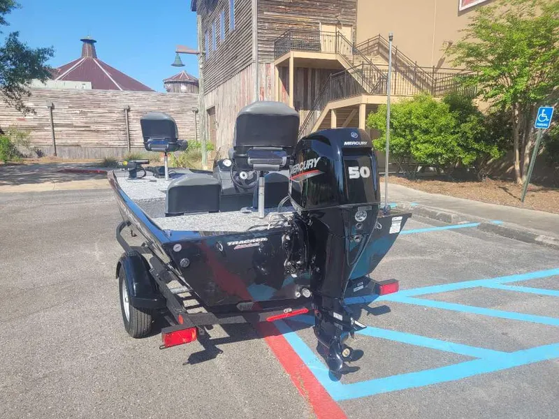 Slide: The Image of 2025 Tracker Pro 170 boat with Mercury 50 engine in a parking lot. - 2