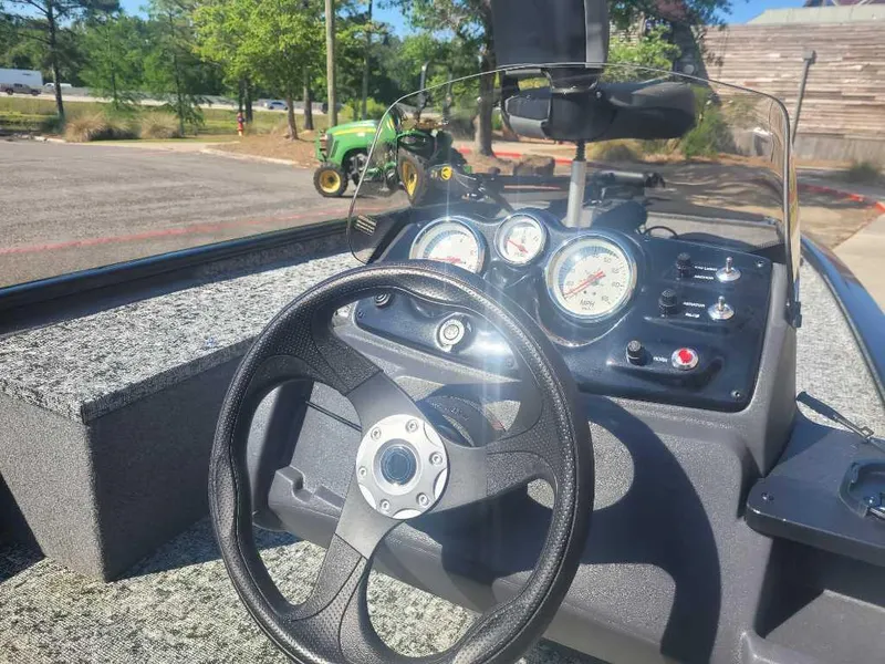 Slide: The Image of 2025 Tracker Pro 170 boat dashboard with steering wheel and gauges in a sunny outdoor setting. - 5