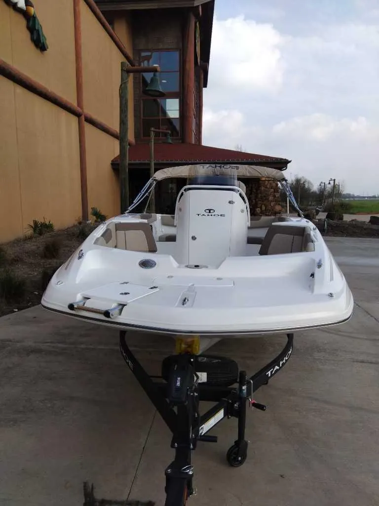 Slide: The Image of 2025 Tahoe 2150 CC boat on trailer, parked outdoors near a building. - 1