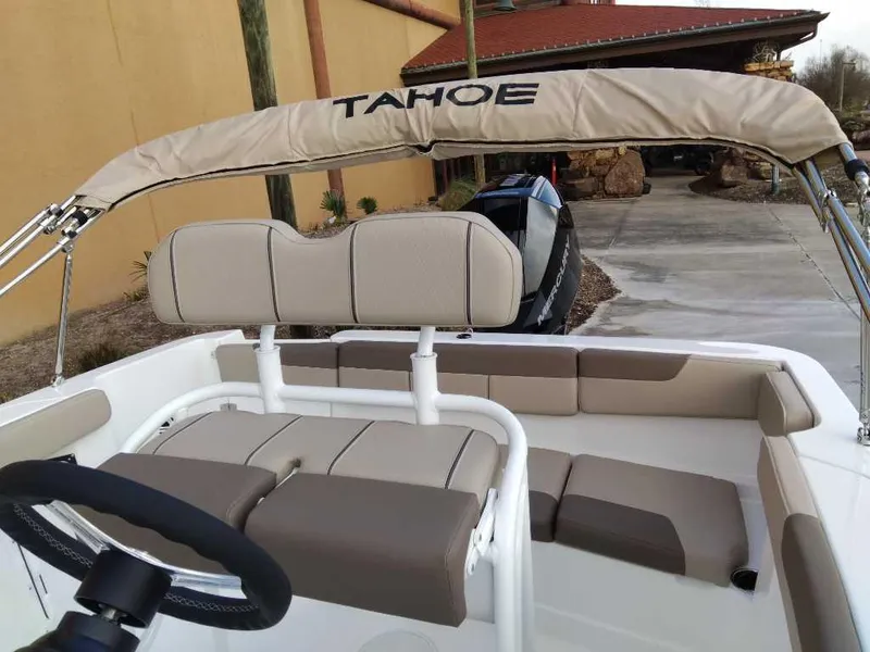 Slide: The Image of 2025 Tahoe 2150 CC boat interior with beige seating and steering wheel. - 3