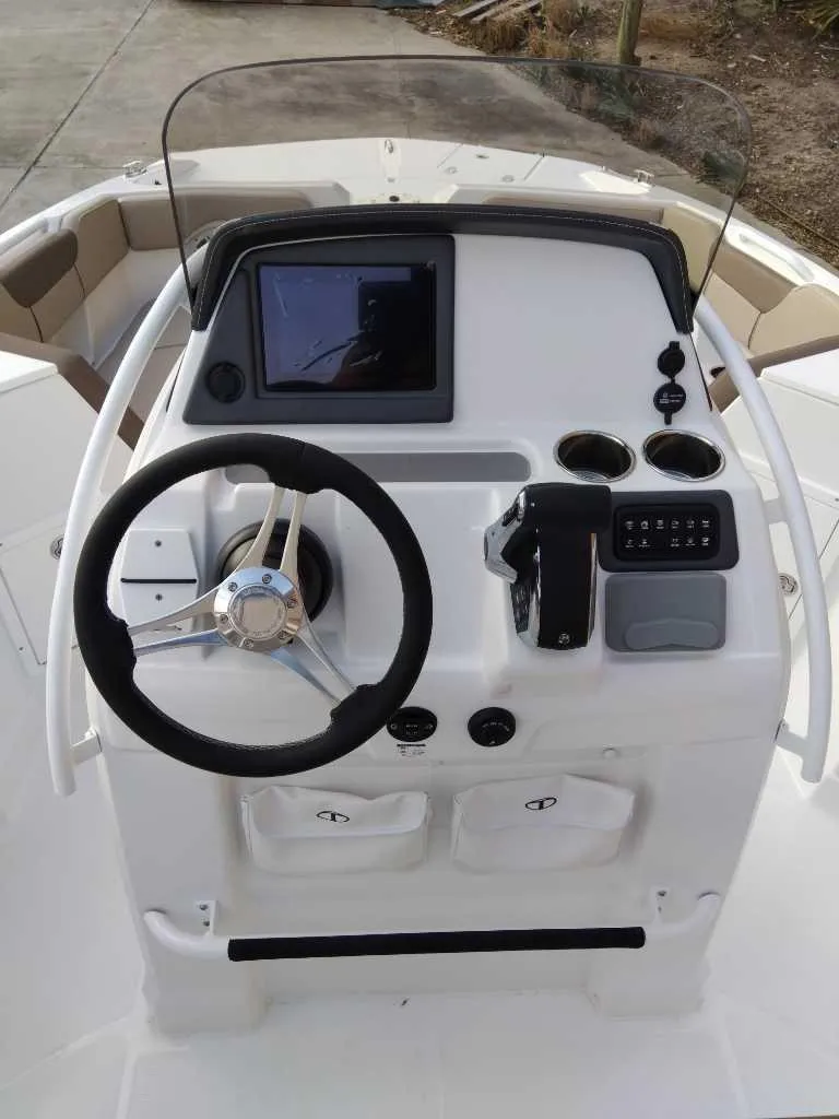 Slide: The Image of 2025 Tahoe 2150 CC boat dashboard with steering wheel and control panel. - 4
