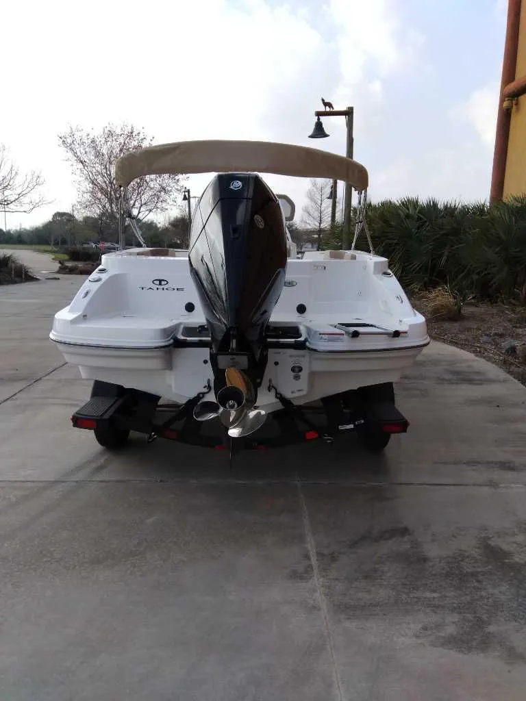 Slide: The Image of 2025 Tahoe 2150 CC boat, rear view with outboard motor, parked on a concrete surface. - 7
