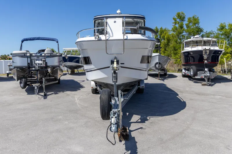 Slide: The Image of 2022 Jeanneau NC Sport 895 boat on trailer, surrounded by other boats, under clear blue sky. - 10