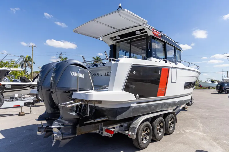 Slide: The Image of 2022 Jeanneau NC Sport 895 boat on trailer with Yamaha engines, outdoor setting. - 14