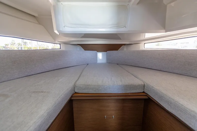 Slide: The Image of 2022 Jeanneau NC Sport 895 cabin interior with gray cushions and wooden accents. - 15