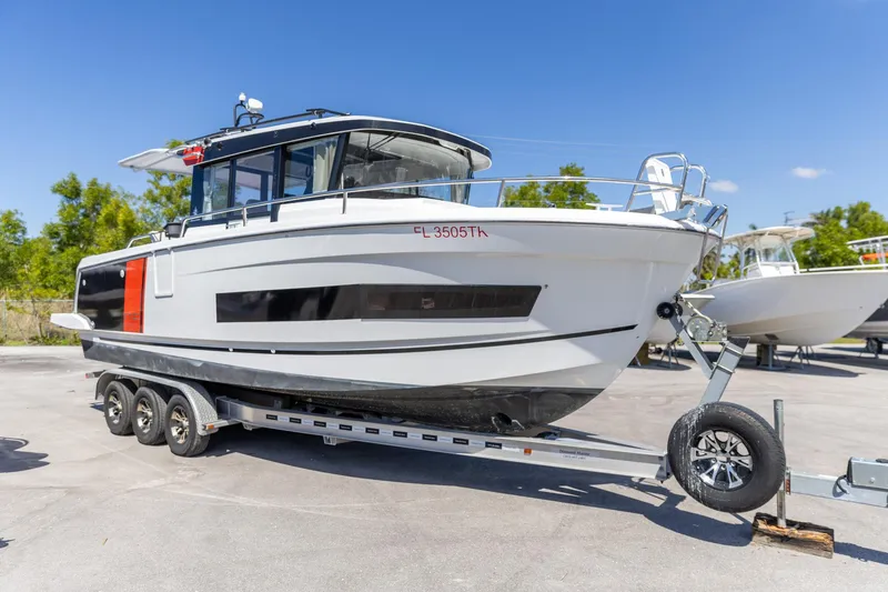 Slide: The Image of 2022 Jeanneau NC Sport 895 boat on trailer, parked outdoors under clear blue sky. - 16