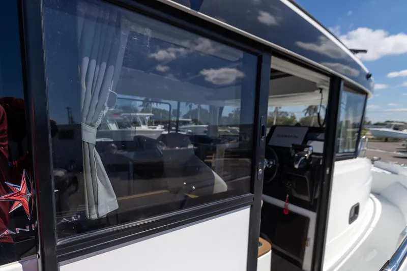 Slide: The Image of 2022 Jeanneau NC Sport 895 boat, side view with windows and interior glimpse. - 18