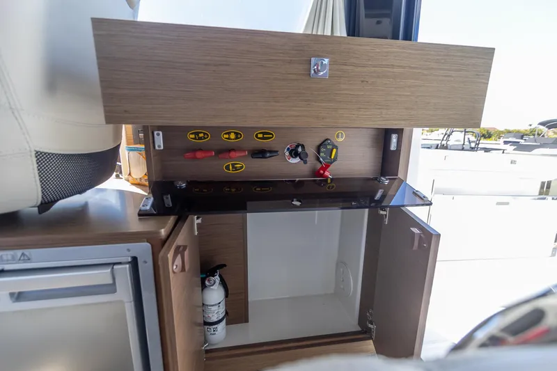 Slide: The Image of Interior of 2022 Jeanneau NC Sport 895 boat showing storage compartment and safety equipment. - 24