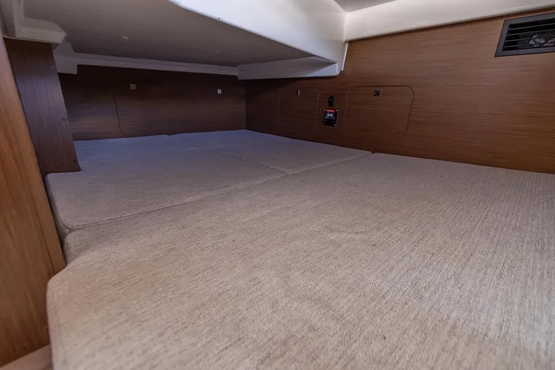 Slide: The Image of 2022 Jeanneau NC Sport 895 cabin interior with beige upholstery and wooden paneling. - 26