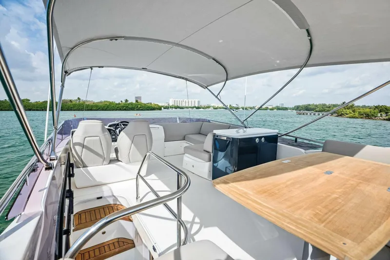 Slide: The Image of Flybridge view of 2019 Princess 43 yacht with seating and table, on calm waters. - 26