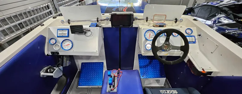 Slide: The Image of Cockpit of 2003 Ultimate Warlock 29 World Class Offshore Race boat with blue seating and gauges. - 13