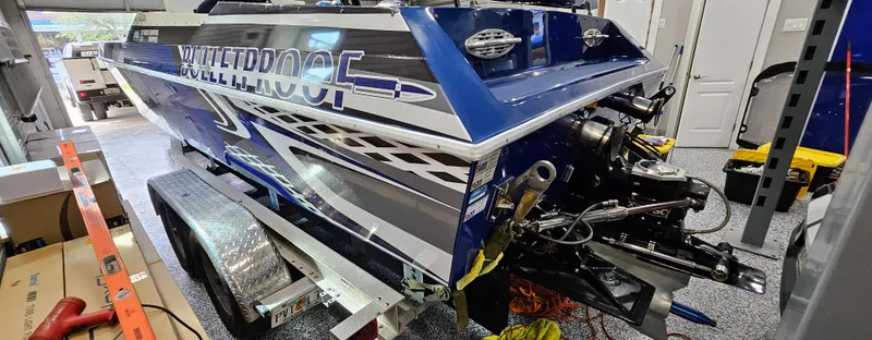 Slide: The Image of 2003 Ultimate Warlock 29 World Class Offshore Race boat in a garage on a trailer. - 21
