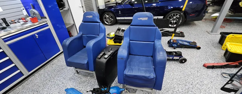 Slide: The Image of Two blue racing seats in a garage with tools and a car. - 24