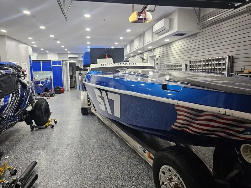 Slide: The Image of 2003 Ultimate Warlock 29 World Class Offshore Race boat in a garage, blue with number 517. - 25
