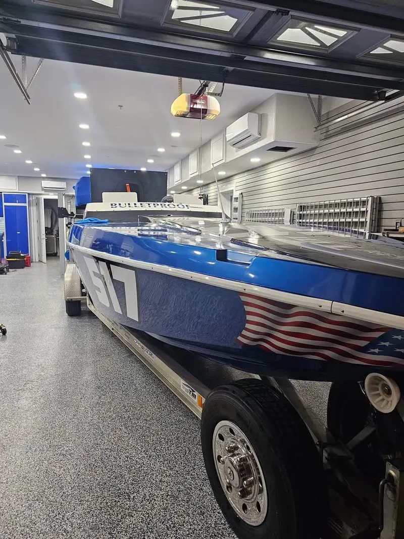 Slide: The Image of 2003 Ultimate Warlock 29 World Class Offshore Race boat in garage, blue with American flag design. - 41