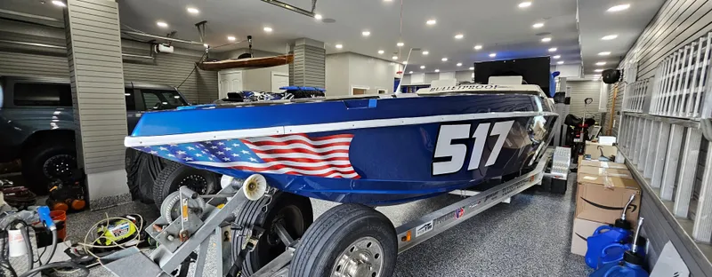 Slide: The Image of 2003 Ultimate Warlock 29 World Class Offshore Race boat in garage, featuring American flag design. - 8