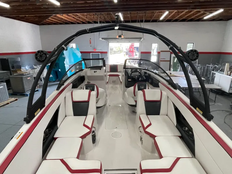 Slide: The Image of 2015 Scarab 255 HO Impulse boat interior with white and red seating in a garage. - 10
