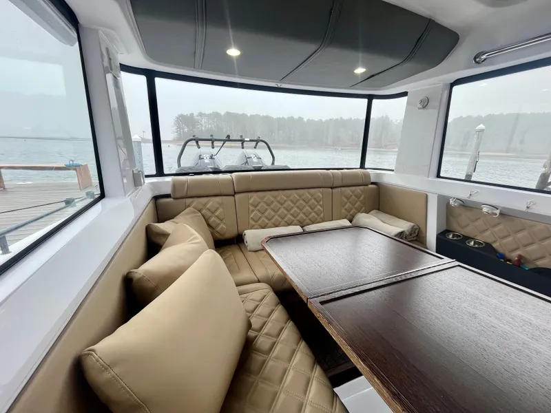 Slide: The Image of Luxurious interior of 2021 Axopar 37 Cabin with wet bar, featuring plush seating and scenic windows. - 10