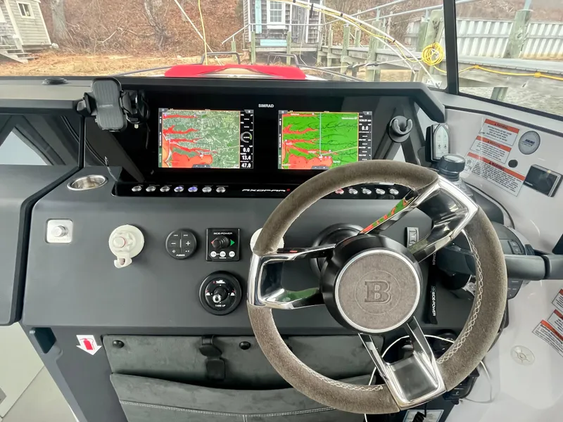 Slide: The Image of Steering console of 2021 Axopar 37 Cabin with navigation screens and controls. - 12