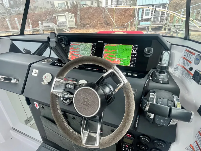 Slide: The Image of Steering wheel and dashboard of 2021 Axopar 37 Cabin with navigation screens. - 13