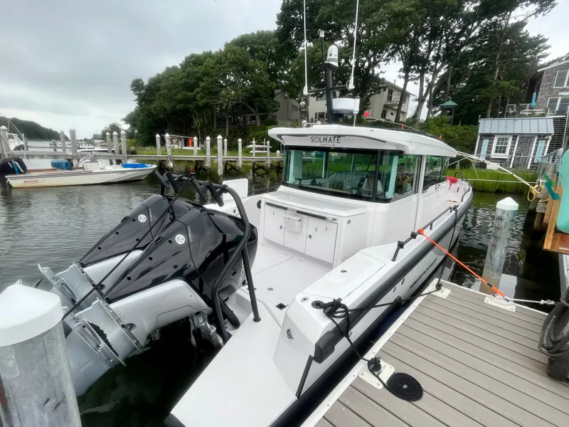 Slide: The Image of 2021 Axopar 37 Cabin with Wet Bar docked at marina, featuring dual outboard engines. - 3