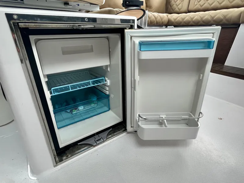 Slide: The Image of Open mini fridge in 2021 Axopar 37 Cabin Wet Bar, showcasing interior storage. - 30
