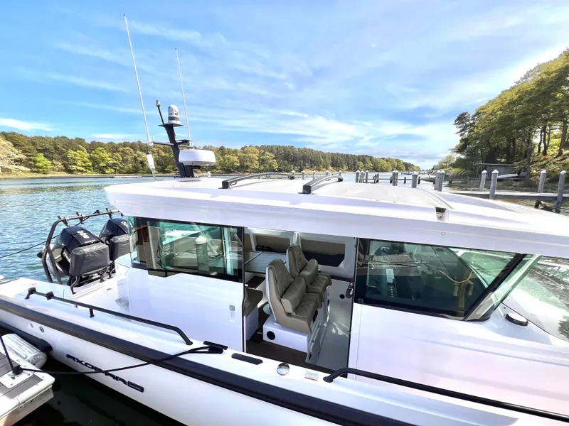 Slide: The Image of 2021 Axopar 37 XC Cross Cabin with Wet Bar, docked by a scenic waterfront. - 31