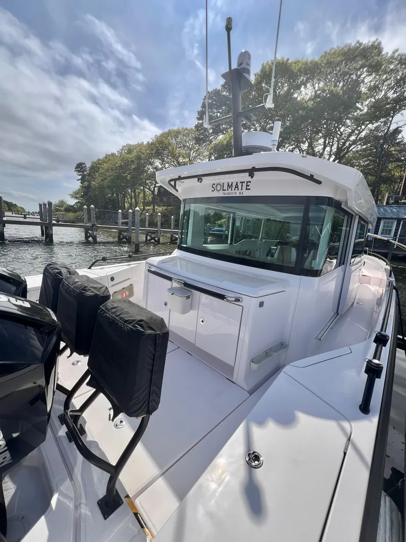 Slide: The Image of 2021 Axopar 37 XC Cross Cabin with wet bar, docked near trees and water. - 33