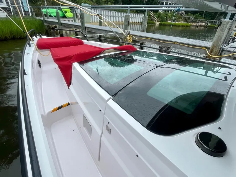 Slide: The Image of 2021 Axopar 37 Cabin with Wet Bar, docked, featuring sleek design and red seating. - 37