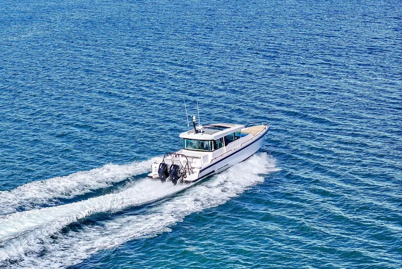 Slide: The Image of 2021 Axopar 37 Cabin with Wet Bar cruising on open blue water. - 4