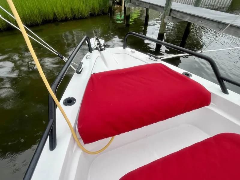 Slide: The Image of Axopar 37 Cabin 2021 boat with red seating, docked near lush greenery. - 40