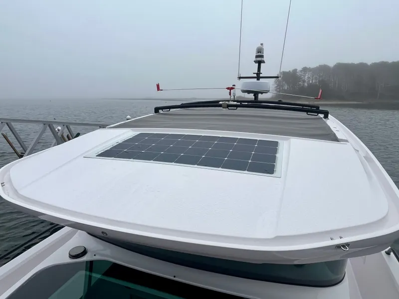 Slide: The Image of 2021 Axopar 37 Cabin with solar panel on roof, docked on a foggy day. - 44