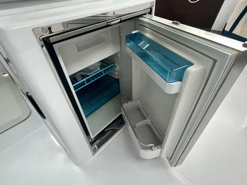 Slide: The Image of Open refrigerator in 2021 Axopar 37 Cabin Wet Bar, showcasing interior storage space. - 47