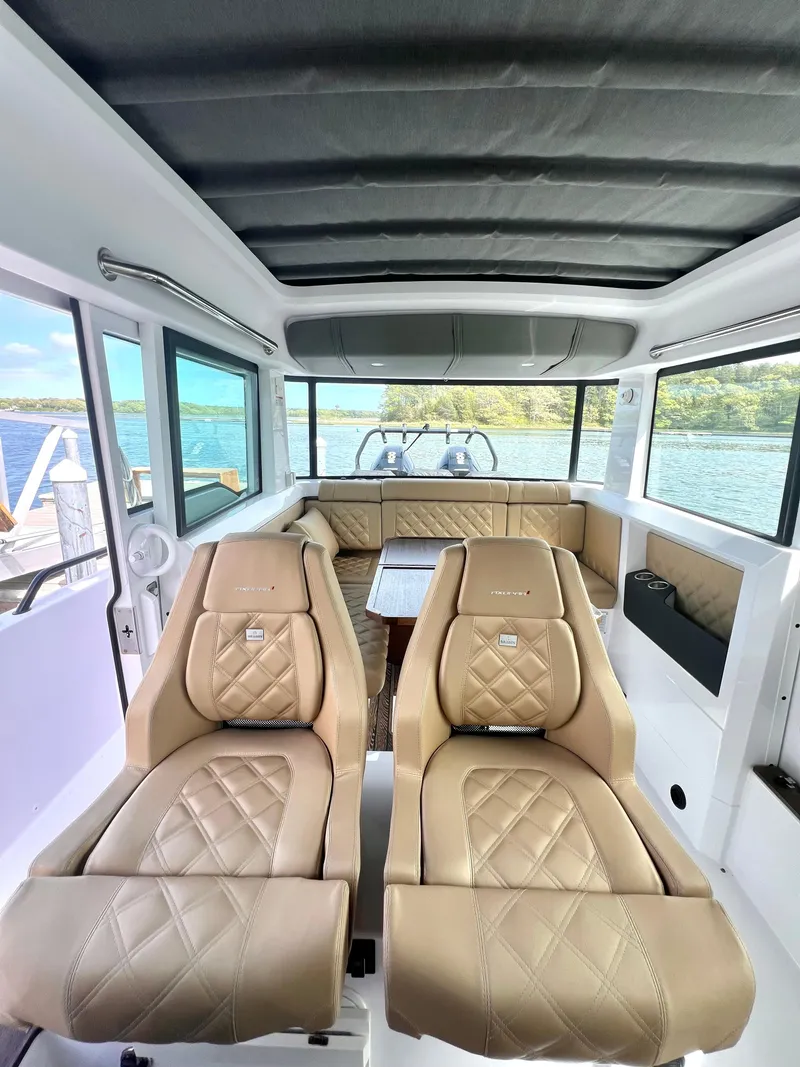Slide: The Image of 2021 Axopar 37 XC Cross Cabin interior with luxurious seating and panoramic windows. - 5
