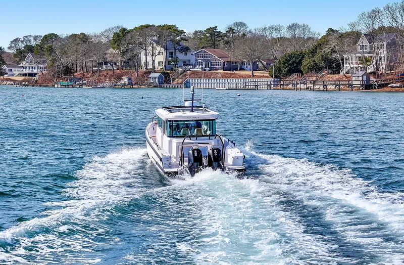 Slide: The Image of 2021 Axopar 37 Cabin with Wet Bar cruising on a scenic lake. - 50