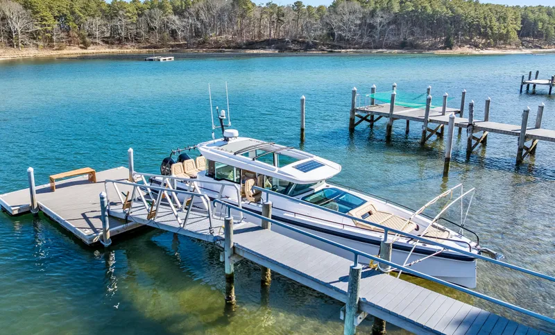 Slide: The Image of 2021 Axopar 37 Cabin with Wet Bar docked on clear blue water. - 51