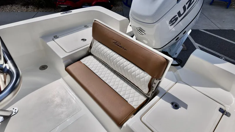 Slide: The Image of 2025 Pioneer 220 Bay Sport boat with cushioned seating and Suzuki outboard motor. - 15