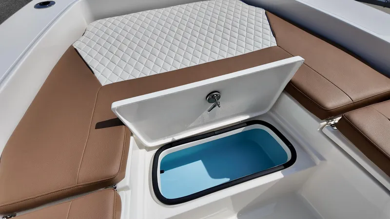 Slide: The Image of 2025 Pioneer 220 Bay Sport boat interior with cushioned seating and storage compartment. - 6