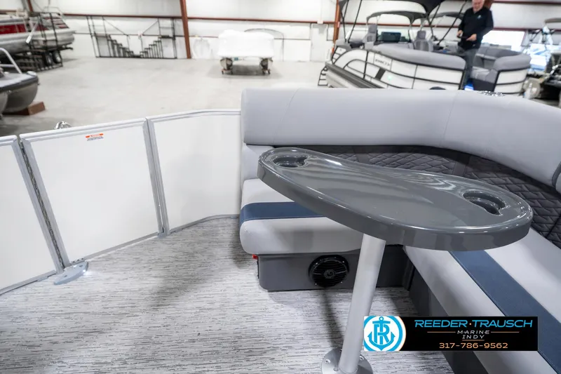 Slide: The Image of 2025 Bennington 22 SLS pontoon boat interior with seating and table in showroom. - 17