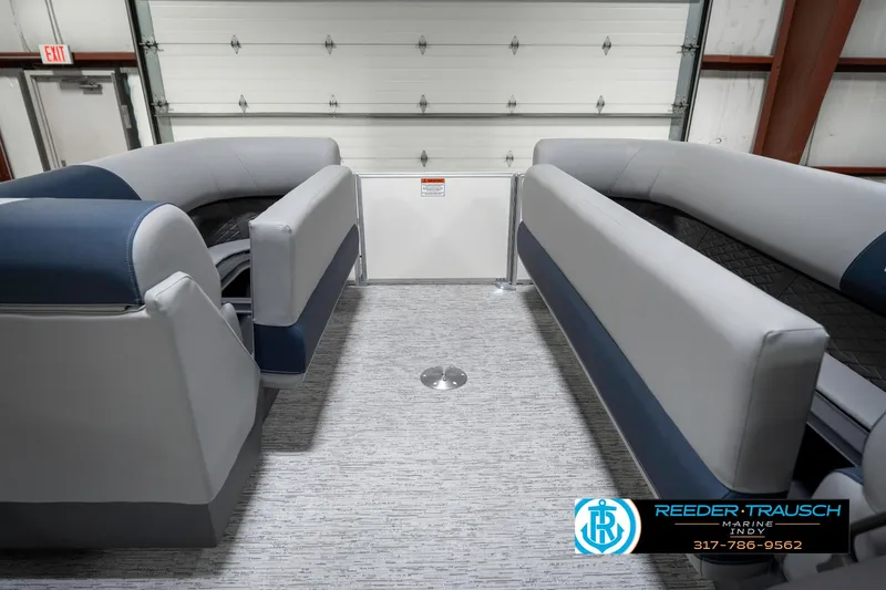 Slide: The Image of 2025 Bennington 22 SLS boat interior with gray and blue seating in a showroom. - 22