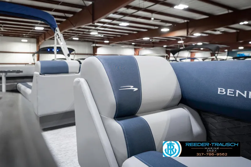 Slide: The Image of 2025 Bennington 22 SLS boat interior with blue and gray seating in showroom. - 23