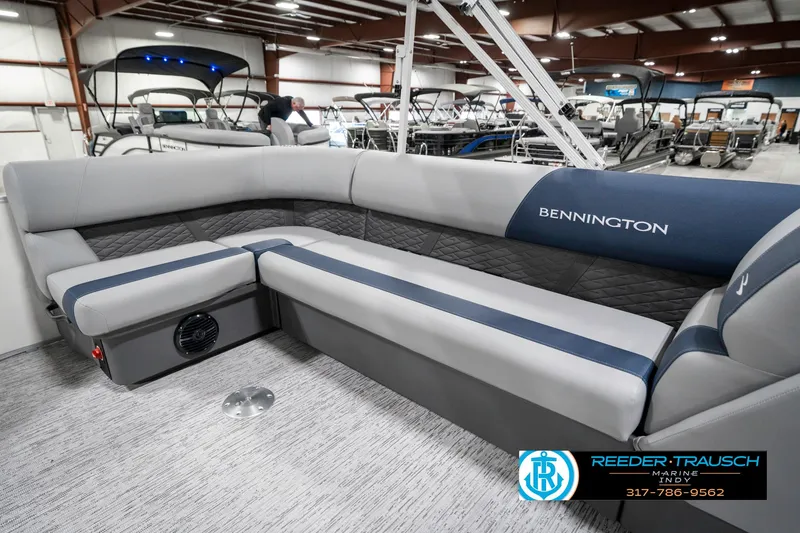 Slide: The Image of 2025 Bennington 22 SLS pontoon boat interior with gray and blue seating in showroom. - 26