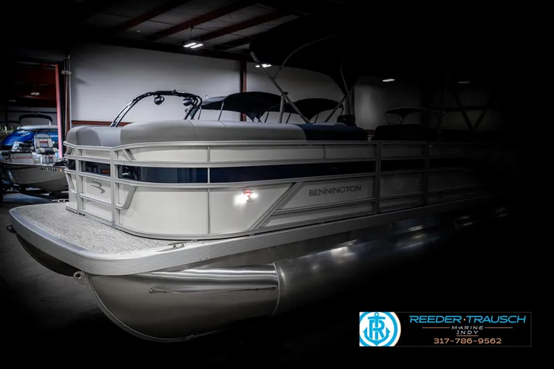 Slide: The Image of 2025 Bennington 22 SLS pontoon boat in showroom, side view with logo. - 3