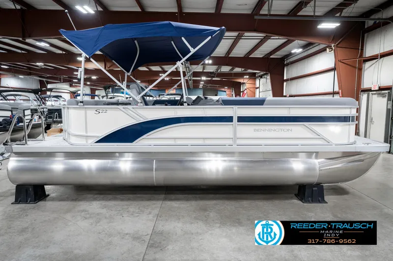 Slide: The Image of 2025 Bennington 22 SLS pontoon boat with blue canopy in showroom. - 6
