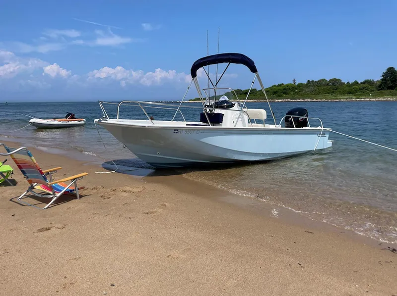Slide: The Image of Boston Whaler 190 Montauk 2020 boat anchored on sandy beach with clear blue sky. - 4