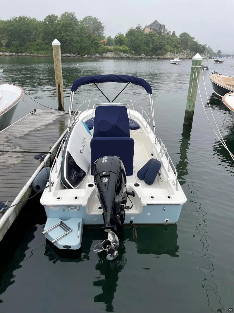 Slide: The Image of 2020 Boston Whaler 190 Montauk docked in a serene marina setting. - 9
