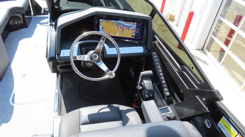 Slide: The Image of 2025 South Bay 25 Sport CR9 3 boat dashboard with steering wheel and navigation display. - 3