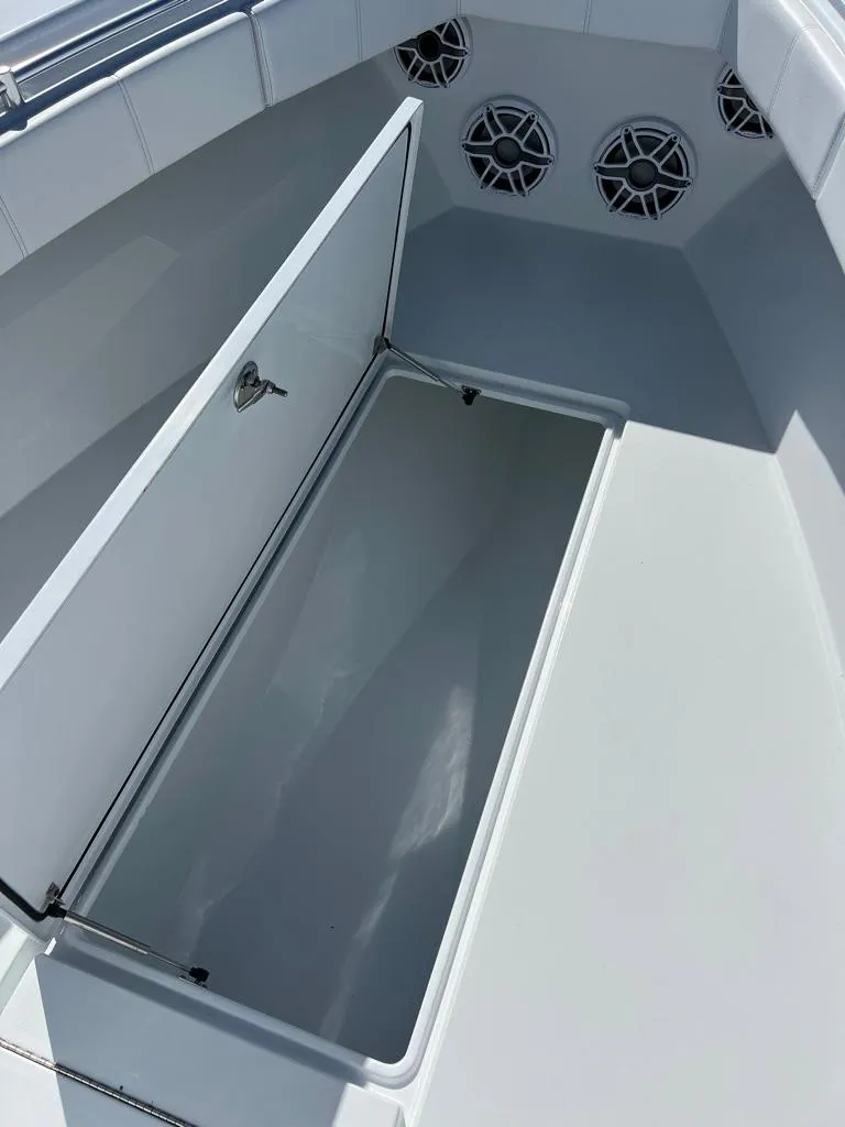 Slide: The Image of 2024 Contender 35 ST boat storage compartment with open lid and speaker system. - 10